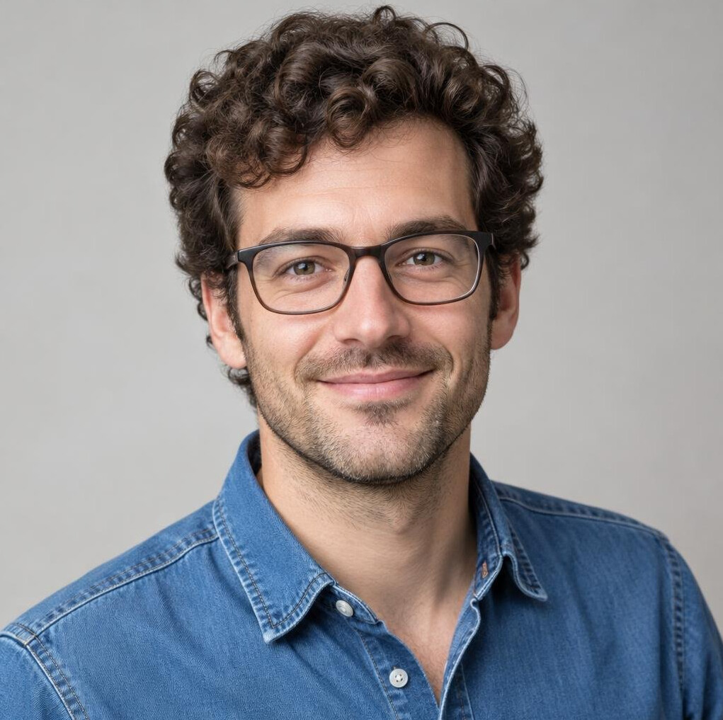 Portrait of a young man with curly dark hair and glasses
